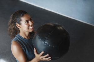 Femme utilisant une wall-ball pour faire son entraînement